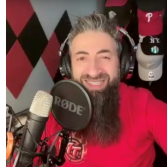 Terry, wearing a red shirt and black headphones, in front of a microphone.