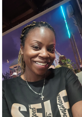 Janelle, wearing a black shirt, and hair in a ponytail.