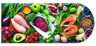 Colorful spread of fresh healthy foods including salmon, chicken, vegetables, fruits, and grains.