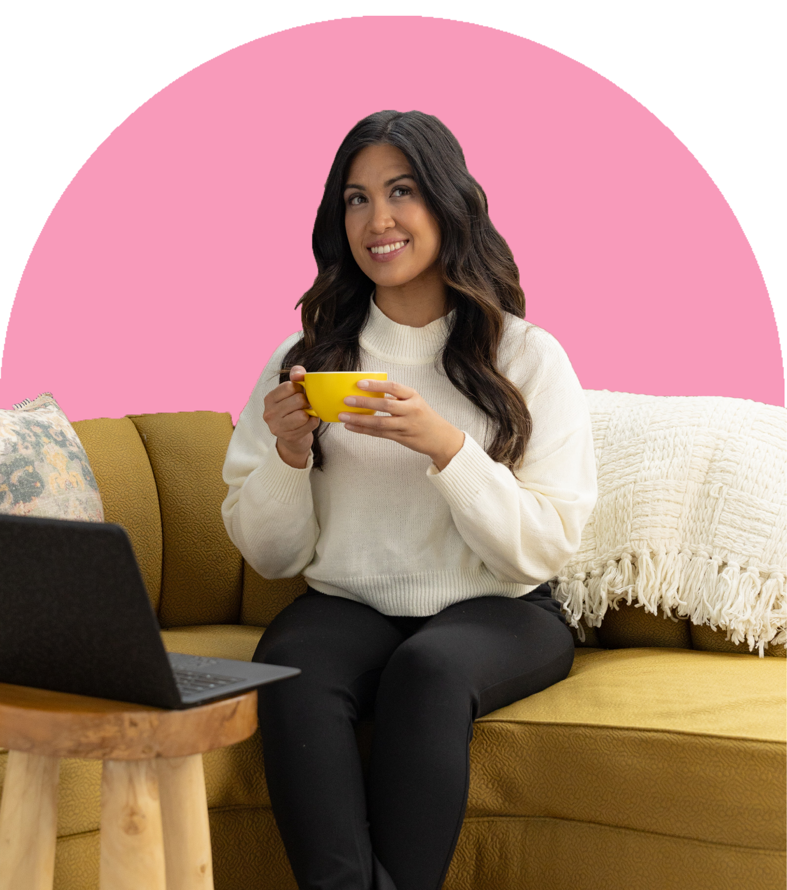 A woman with long, wavy dark hair holds a tea by her open laptop.