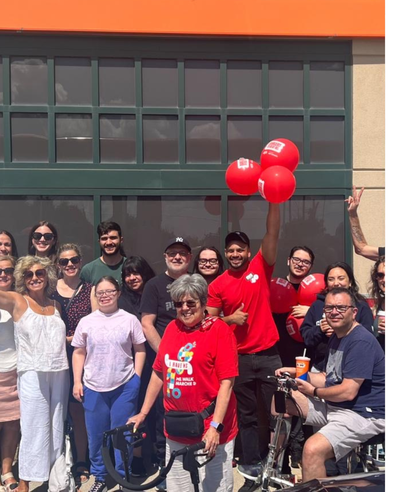 Vivek tient des ballons au logo du Rendez-vous A&W pour stopper la SP. Il est debout devant son restaurant A&W et est accompagné de son personnel et de membres de la collectivité.