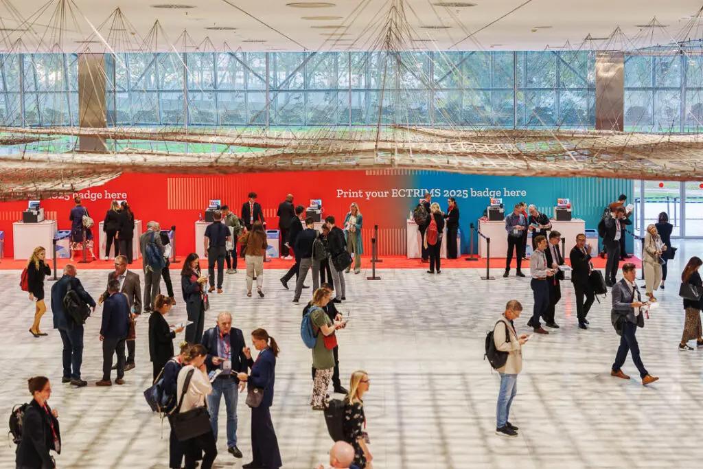 ECTRIMS meeting hall with people networking.