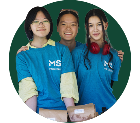 Three young girls stand shoulder to shoulder wearing blue MS Canada t-shirts.