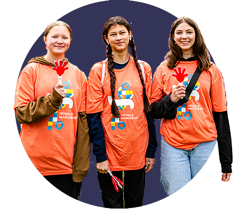 Three young adults stand together in matching orange t-shirts.