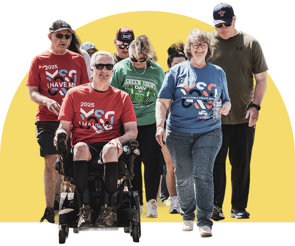 Group of people living with ms walking together outdoors, one in a wheelchair