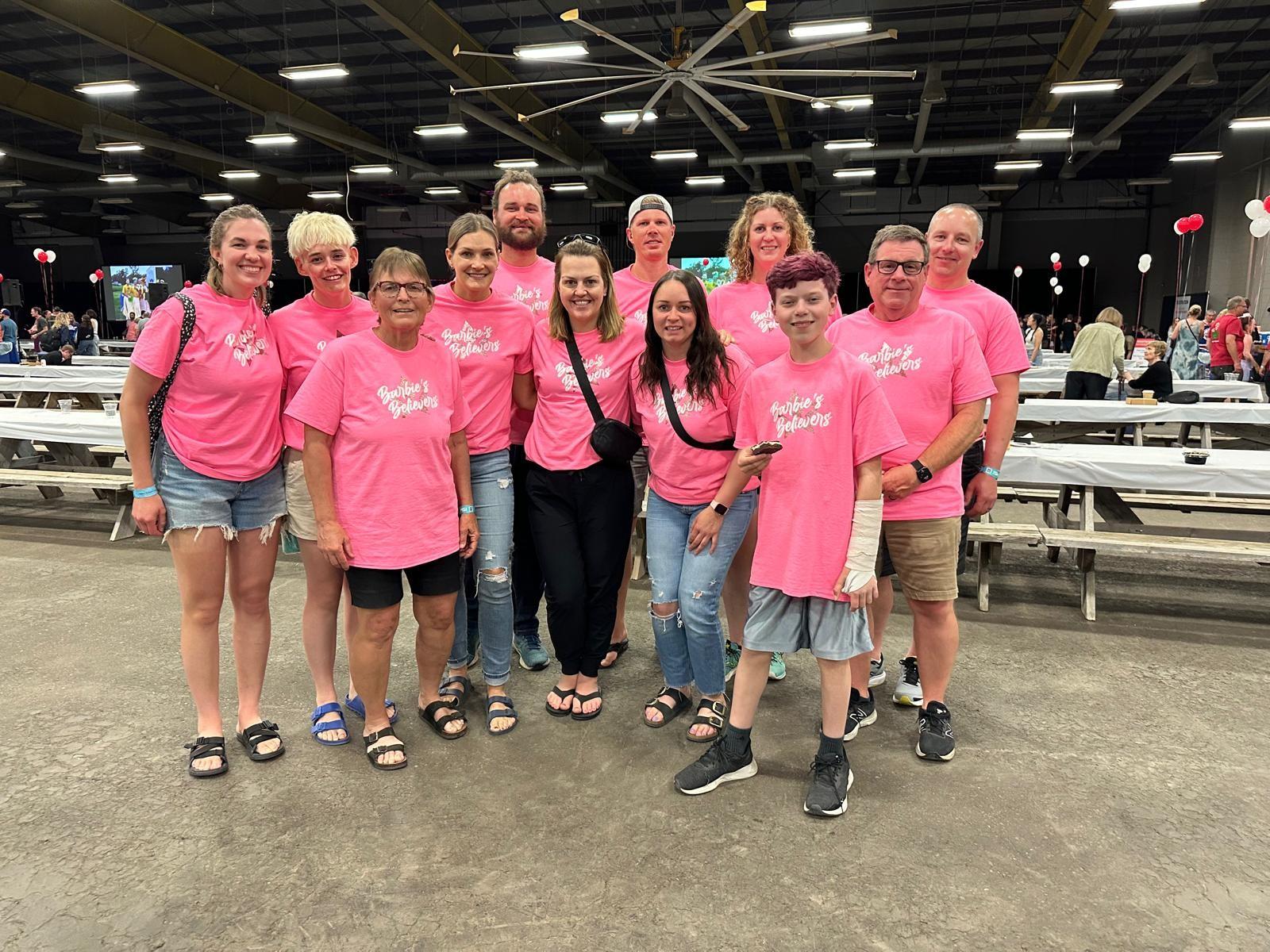 Alli et les membres de l’équipe Barbie's Believers portent des t-shirts roses identiques. 