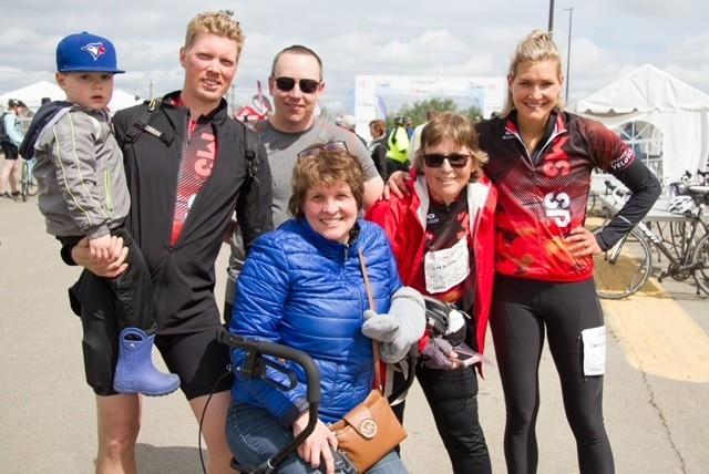 Alli et sa famille sont à l’extérieur lors d’un événement du Vélo SP et sourient devant l’objectif. Certaines personnes portent un maillot du Vélo SP. 