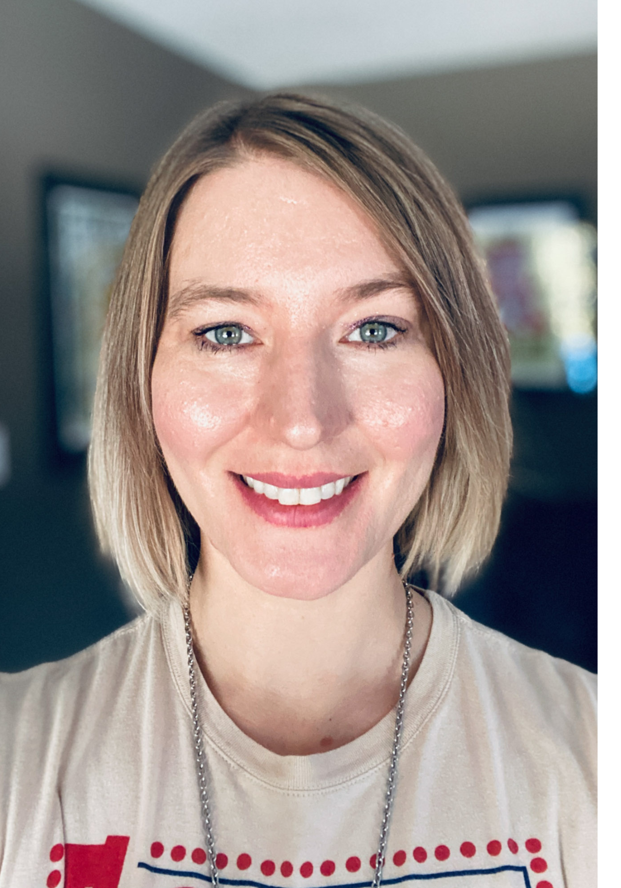 Jaclyn a des cheveux blonds et courts et porte un haut décontracté – elle est photographiée à l’extérieur. 