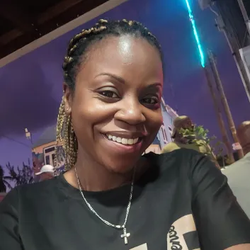 Janelle, wearing a black shirt, and hair in a ponytail.