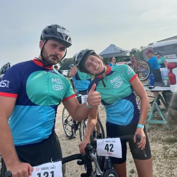 Mika et son mari sourient devant l’objectif. Ils portent un casque sur la tête et leur tenue du Vélo SP. Ils sont debout à côté de leur vélo.